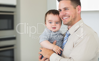 Happy businessman carrying baby