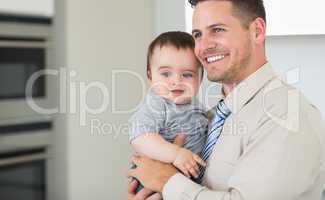 Happy businessman carrying baby