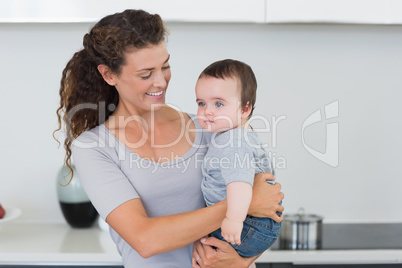 Smiling mother carrying baby