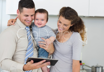 Happy baby with parents using digital tablet