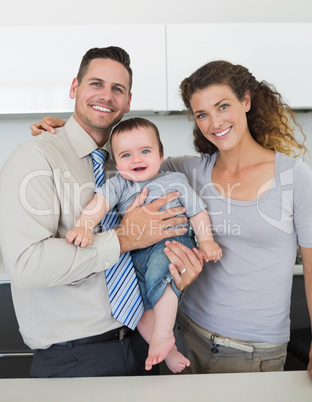 Happy parents with baby in kitchen