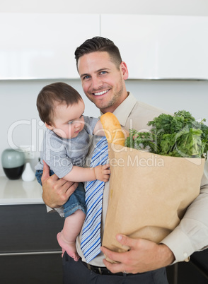 Businessman carrying groceries and baby