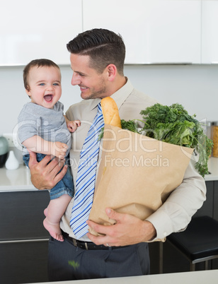 Businessman with grocery carrying baby