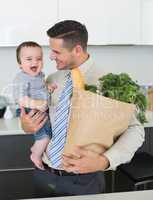Businessman with grocery carrying baby