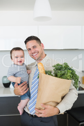 Father carrying baby boy and vegetables