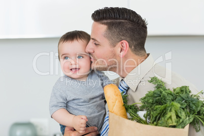 Loving businessman kissing baby boy