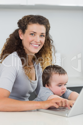 Woman with baby using laptop