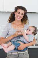 Happy mother feeding milk to baby