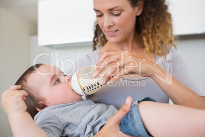 Mother feeding milk to cute baby