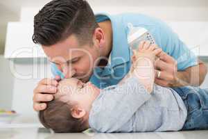 Loving father kissing baby on forehead