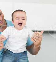 Cheerful baby with father at home