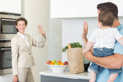 Family waving goodbye to businesswoman
