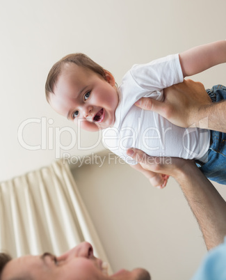 cheerful baby being carried by father
