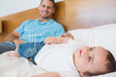 Smiling baby lying on bed