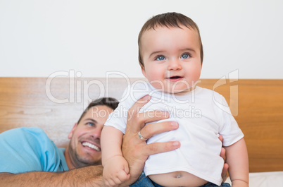 Cute baby with father in bed