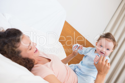 Smiling baby playing with mother