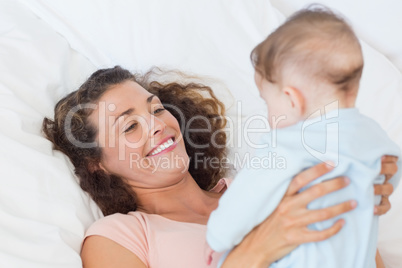 Smiing mother playing with baby