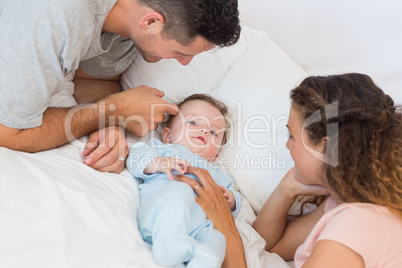 Loving parents playing with baby