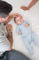 Loving father with baby on bed