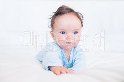 Adorable baby looking away in bed