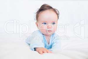 Adorable baby looking away in bed