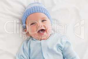 Portrait of cheerful baby in bed