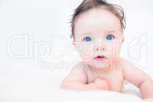 Lovely baby with blue eyes in bed