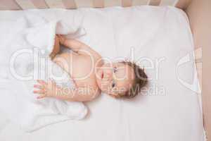Adorable baby boy lying in crib