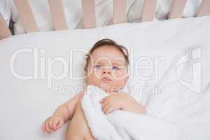 Baby with blanket in crib