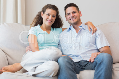 Happy couple sitting on sofa