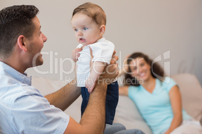 Happy man playing with cute baby
