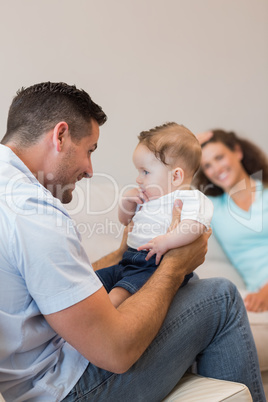 Happy man playing with baby