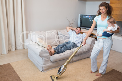 Woman cleaning house while carrying baby