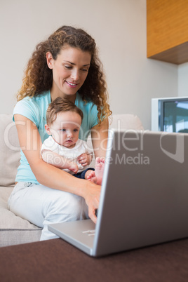 Baby with mother using laptop