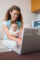 Baby with mother using laptop
