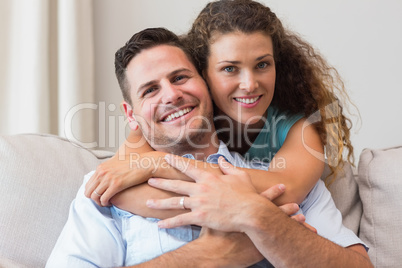 Loving woman embracing man at home