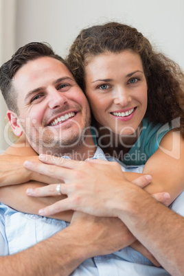 Smiling woman embracing man at home