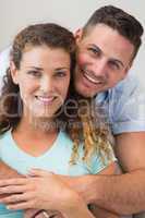 Affectionate man embracing woman  at home