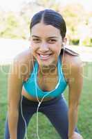 Portrait of happy fit woman listening music