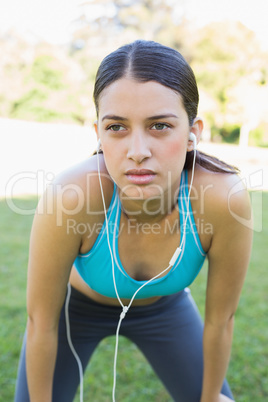 Fit woman listening music in park