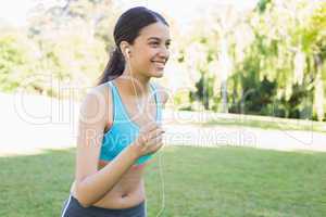 Sporty woman jogging while listening music