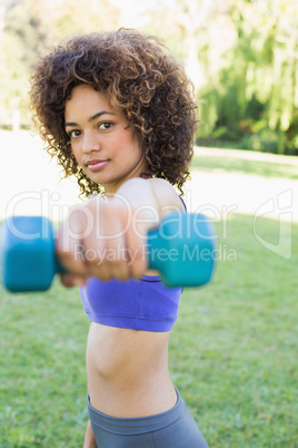 Confident woman lifting dumbbell