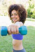 Smiling woman lifting hands weights