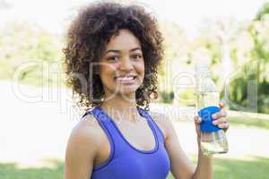 Confident sporty woman holding water bottle