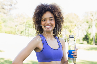 Happy fit woman holding water bottle
