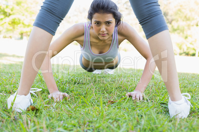 Confident woman doing push ups in park