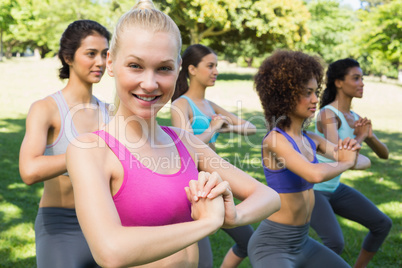 Smiling woman exercising with friends