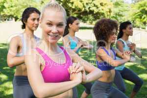 Smiling woman exercising with friends