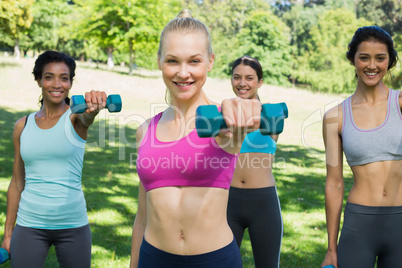 Women lifting weights in park