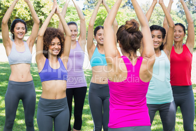Women exercising with female instructor at park